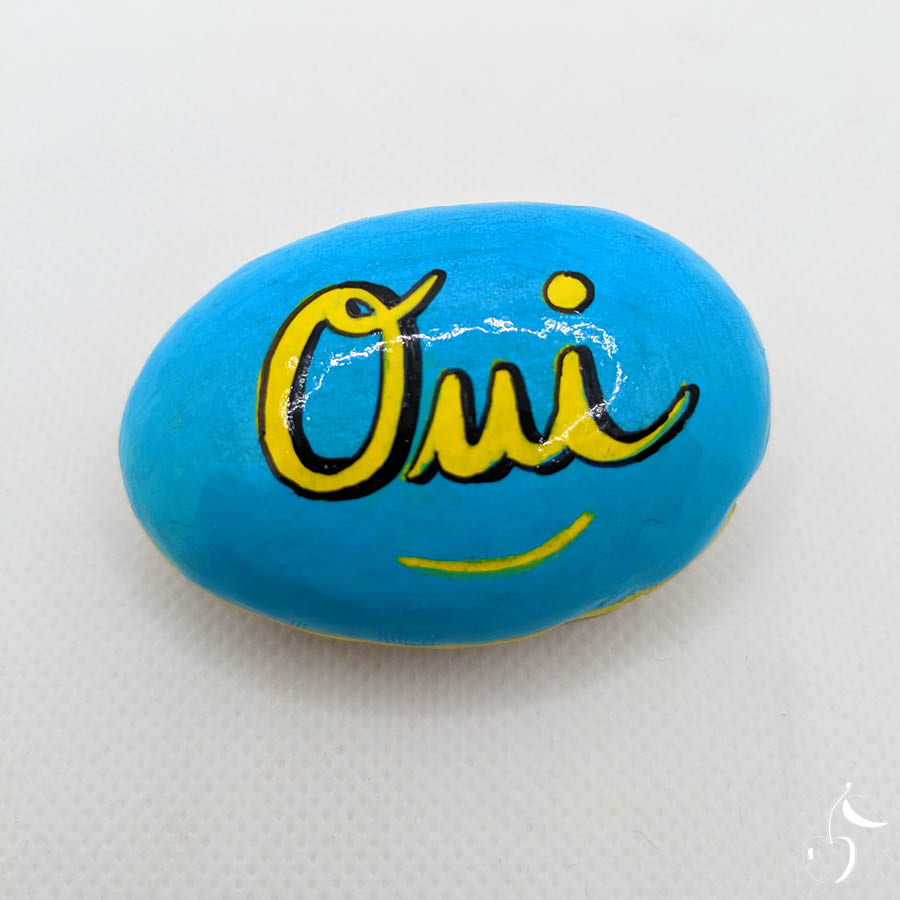 Galet bleu turquoise avec écrit en jaune "Oui"