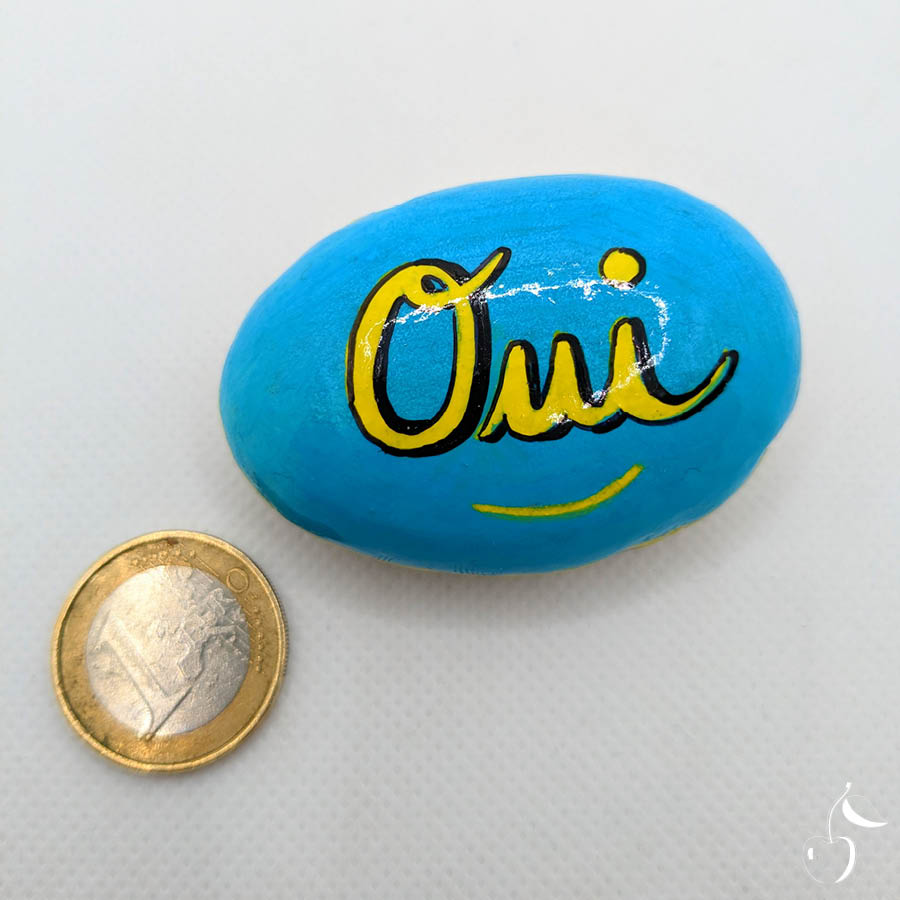 Galet bleu turquoise avec écrit en jaune "Oui"