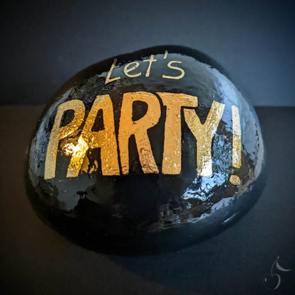 Gros galet noir laqué avec un lettre majuscule en or brillant "Let's PARTY !"