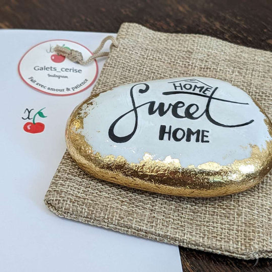 Carte cadeau originale. Galet Home sweet home posé sur un sachet d'emballage Galet cerise