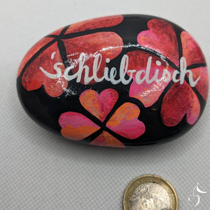 Galet avec coeurs roses et rouges sur fond noir avec écrit dans son centre en dialect colonais "Schliebdisch" Je t'aime